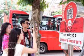 Visitors scan a QR code on the Km0 Ha Giang marker to access tourism information. (Photo: VNA)