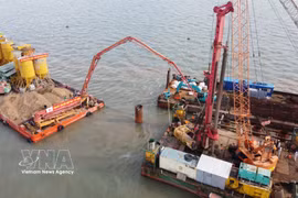 Engineers and workers carry out construction activities at sea. (Photo: VNA)