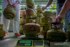 A man weighs a 3 kg LPG cylinder during a surprise inspection in Lumajang, East Java. (Photo: Antara)