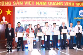 The organisers present certificates of appreciation to speakers who deliver presentations at the symposium. (Photo: VNA)