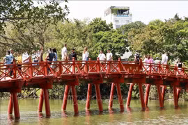 Tourists at The Huc Bridge, a popular spot in in the heart of Hanoi. (Photo: VNA)