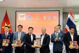 Overseas Vietnamese receive bilingual book “President Ho Chi Minh in Thailand”. (Photo: VNA)