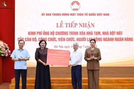 President of the Vietnam Fatherland Front (VFF) Central Committee Do Van Chien receives the token of 82 billion VND from Governor of the State Bank of Vietnam Nguyen Thi Hong. (Photo: VNA)