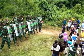 In the simulated scenario, Lao Bao International Border Gate Station (Vietnam) coordinates with Border Company 320 (Laos) to set up checkpoints and conduct public information campaigns to prevent free migration and illegal cross-border movements. (Photo published by VNA) 