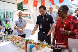 Minister Counsellor Pham Quang Huy (in black) introduces Vietnam's pavilion to WTO Director-General Ngozi Okonjo-Iweala. (Photo: VNA)