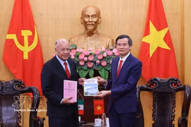President of the Ho Chi Minh National Academy of Politics Assoc. Prof. Dr. Doan Minh Huan (R) presents books to PT General Secretary Alberto Anaya Gutiérrez at their meeting in Hanoi on August 19. (Photo: VNA)