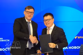 Editor-in-chief of Nhan Dan newspaper Le Quoc Minh (right) signs an agreement with Rossiya Segodnya Media Group (Photo: VNA)
