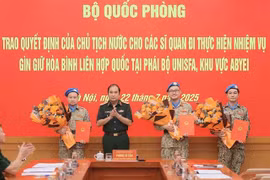 Senior Lieutenant General Phung Si Tan (second from left), Deputy Chief of the General Staff, presents decisions of the State President and the Minister of National Defence to three officers who are about to depart for duties at the UN peacekeeping mission in Abyei. (Photo: VNA)