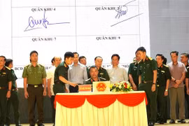 Representatives of ministries, agencies, and 21 coastal provinces and cities sign an agreement to carry out a peak emulation campaign against IUU fishing. (Photo: VNA) 