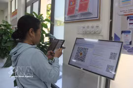 A resident scans a QR code to get a queue number at the public administrative service centre in Hoa Xuan ward, Da Nang city (Photo: VNA)