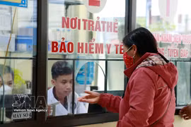 A resident in Lao Cai province registers for medical examination and treatment using health insurance card at a local health centre. (Photo: VNA) 