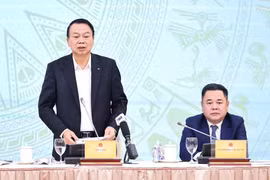 Deputy Minister of Finance Nguyen Duc Chi (standing) addresses the press conference (Photo: VNA)