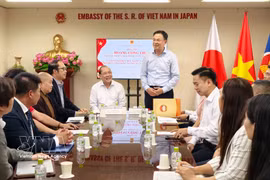 Vietnamese Ambassador to Japan Pham Quang Hieu (standing) briefs the delegation on the development of the Vietnamese community and related affairs in Japan. (Photo: VNA)