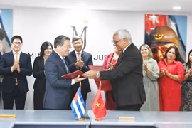 Visiting Vietnamese Minister of Justice Nguyen Hai Ninh (L) and his Cuban counterpart Oscar Manuel Silvera Martínez exchange documents after signing an agreement on a technical assistance project for the Cuban Ministry of Justice. (Photo: VNA)