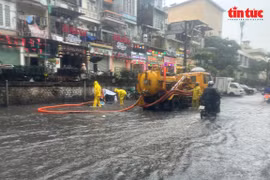 Workers of the Hanoi Sewerage and Drainage One Member Limited Liability Company are working in a street in Hanoi. (Photo: VNA)