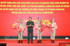 Senior Lieutenant General Nguyen Truong Thang, Deputy Minister of National Defence (second, left), presents the decisions to three officers departing for peacekeeping duties at the UN Mission in South Sudan (UNMISS) (Photo: VNA)