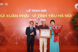 Le Quoc Minh (left), Chairman of the Vietnam Journalists’ Association and Editor-in-Chief of Nhan dan Newspaper and Vu Viet Trang (right), General Director of the Vietnam News Agency, present the Grand Prize to musician Tran Tien. (Photo: VNA) 