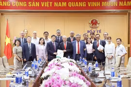 Standing Deputy Minister of Health Vu Manh Ha, General Secretary of the Mexican Labour Party Alberto Anaya Gutierrez and other officials pose for a group photo. (Photo: VietnamPlus)
