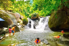 Tourists cool off in a stream on Dinh Mountain. (Photo: VNA)