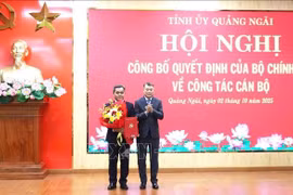 Le Minh Hung (R), Politburo member, Secretary of the Party Central Committee and Chairman of its Organisation Commission, hands over the appointment decision and congratulation flowers to Ho Van Nien, the new Secretary of the Quang Ngai Party Committee (Photo: VNA)