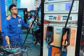 A worker refuels a motorbike at a Petrolimex station. (Photo: VNA)