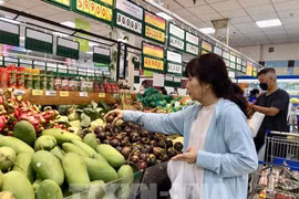 A consumer buys fruits at a supermarket in Ho Chi Minh City. (Photo: VNA)