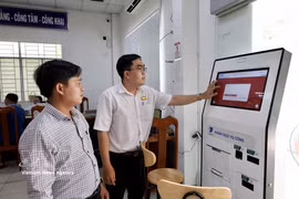 A civil servant at the Public Administrative Service Centre of Long Xuyen ward, An Giang province, assists a resident in completing online procedures via the National Public Service Portal. (Photo: VNA)