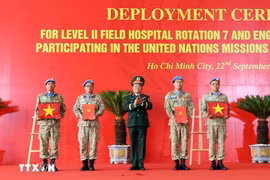 On behalf of the State President, Deputy Minister of National Defence Senior Lieutenant General Hoang Xuan Chien Hoang Xuan Chien presents the decision to Vietnamese units assigned to UN peacekeeping missions and hands over the national flag to them. (Photo: VNA)