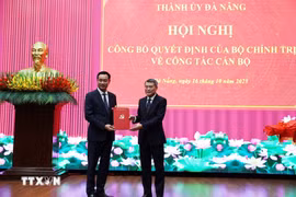 Politburo member, Secretary of the Party Central Committee and Chairman of its Organisation Committee Le Minh Hung (right) hands over the decision to Le Ngoc Quang (Photo: VNA)