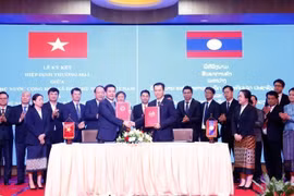 Minister of Industry and Trade Nguyen Hong Dien and his Lao counterpart Malaithong Kommasith sign the Vietnam - Laos Trade Agreement on April 8, 2024. (Photo: VNA)