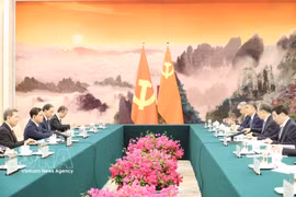 Politburo member, Secretary of the Communist Party of Vietnam (CPV) Central Committee and Chairman of the CPV Central Committee's Commission for Internal Affairs Le Minh Tri (first, left) meets with Wang Huning, Member of the Standing Committee of the Political Bureau of the Communist Party of China (CPC) Central Committee and Chairman of the National Committee of the Chinese People's Political Consultative Conference (CPPCC), in Beijing on July 14. (Photo: VNA)