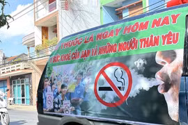 A banner on the side of a car urges people to quit smoking for their own health and that of their loved ones (Photo: VNA)