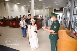 A border guard at the Mong Cai International Border Gate processes exit procedures for passengers at the Bac Luan 1 border gate in Quang Ninh province. (Photo: VNA)