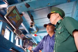 An officer of Phuoc Tinh Border Guard Station checks the vessel monitoring system on a local fishing boat. (Photo: VNA)