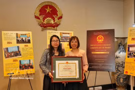 Vietnamese Consul General Nguyen Thanh Ha (L) presents a Certificate of Merit from the Vietnamese Minister of Foreign Affairs to Associate Professor Dr Duong Thi Hong Lien of Curtin University. (Photo: VNA)