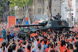 The formations of tanks and armoured vehicles are welcomed by crowds. (Photo: VNA)