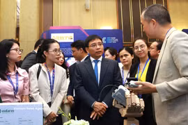 Deputy Prime Minister Nguyen Van Thang talks with technology enterprises on the sidelines of the event. (Photo: VNA)