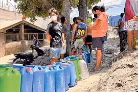 Residents in Barangay Travesia, Guinobatan, Albay, one of the villages reeling from Mayon Volcano’s ashfall, line up for free potable water amid a shortage supply in the area. (Photo: newsinfo.inquirer.net)