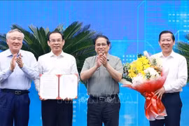 PM Pham Minh Chinh (second from right) presents the Decision approving HCM City's master planning scheme to its leaders. (Photo: VNA)
