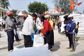 People in difficult circumstances receive rice aid on the occasion of the Lunar New Year Festival in Lak district, Dak Lak province. (Photo: VNA)