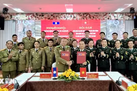 The Quang Tri Border Guard Command and the police of Laos' Salavan province sign the minutes of their annual talks on December 26. (Photo: released by VNA)