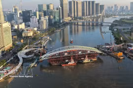 The main span of the pedestrian bridge is tugged to the construction site on October 21, 2026. (Photo: VNA)