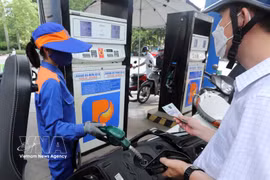A motorcyclist has his vehicle refuelled at a Petrolimex station. (Photo: VNA)