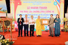 The certificate recognising Cuong Xa Pagoda as the temple with the largest system of stone walls engraved with the Buddhist swastika symbol is handed over to the pagoda's representatives at a ceremony held on May 3. (Photo: VNA)