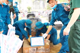 Collecting martyrs' remains to determine their identity. (Photo: VNA)
