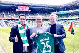 Vietnamese Ambassador to Germany Vu Quang Minh (C) presented with a jersey from Werder Bremen club (Photo: VNA)