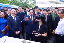PM Chinh and other delegates visit exhibition areas showcasing innovative and digital transformation products of universities and businesses. (Photo: VNA)