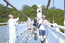 Russian tourists experience the glass bridge at the TTC World – Valley of Love tourist site in Da Lat, Lam Dong province. (Photo: VNA)