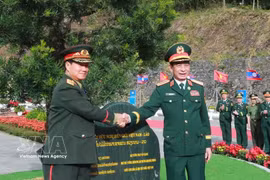 General Phan Van Giang (R) and General Khamlieng Outhakaysone plant a tree at Thanh Thuy border gate. (Illustrative photo: VNA)