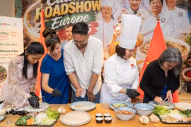 Visitors participate in a live demonstration of pho roll preparation at the event. (Photo: VNA)